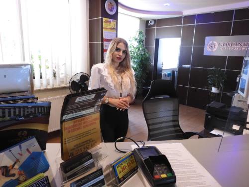 a woman standing next to a table with a phone at Gościniec Biznesowy in Dąbrowa Górnicza