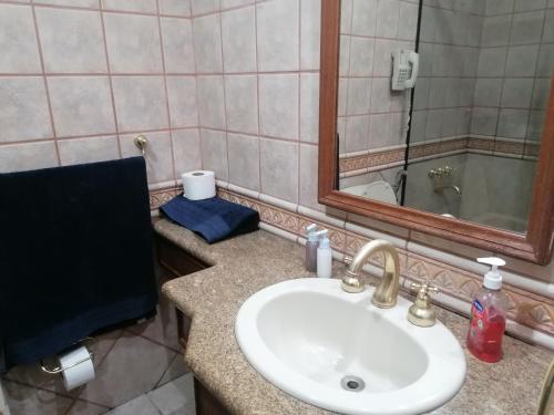 y baño con lavabo y espejo. en Tu Suite Doble en Equipetrol, en Santa Cruz de la Sierra