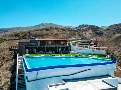een huis met een zwembad op de top van een berg bij RM Green Hotel 