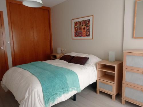 1 dormitorio con 1 cama y 2 mesitas de noche en Apartamento Isidro Parga Pondal, en Laxe