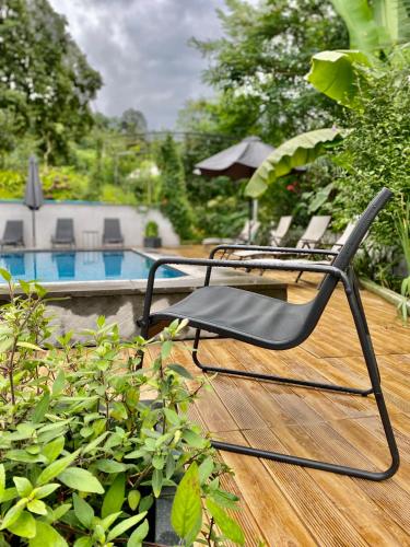 a group of chairs sitting on a deck next to a pool at Guest House Botanical Paradise in Mtsvane Kontskhi