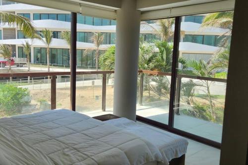 um quarto com uma cama e uma grande janela em Hermoso departamento Acapulco em Acapulco