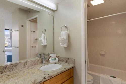 y baño con lavabo y espejo. en Ala Wai Suite 1 Bed Canal View Condo, en Honolulu
