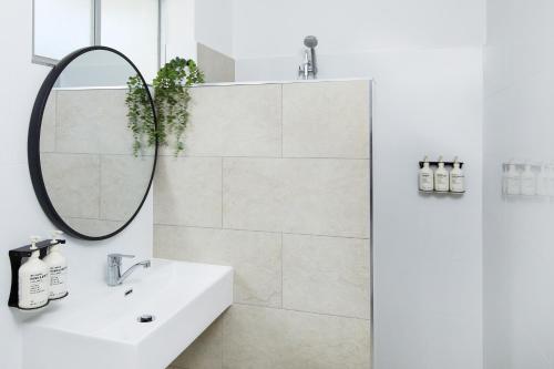 a bathroom with a sink and a mirror at Tessa's on the Beach in Gold Coast