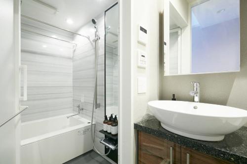 福岡的住宿－LINK HOUSE HOTEL - スマート無人ステイ - Unmanned design hotel，浴室配有白色水槽和淋浴。
