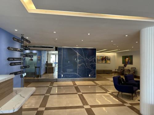 a lobby with a blue wall with a map on it at TRYP by Wyndham Rio de Janeiro Barra Parque Olímpico in Rio de Janeiro