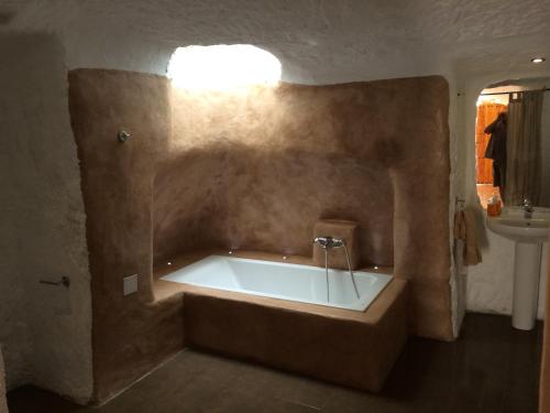 eine große Badewanne im Bad mit Waschbecken in der Unterkunft Cuevas del Cipres in Baza