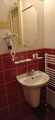 a bathroom with a white sink and a mirror at Hotel U Zlateho jelena in Prague