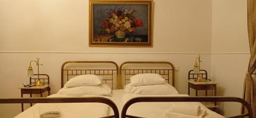 two beds in a bedroom with a painting on the wall at Hotel U Zlateho jelena in Prague
