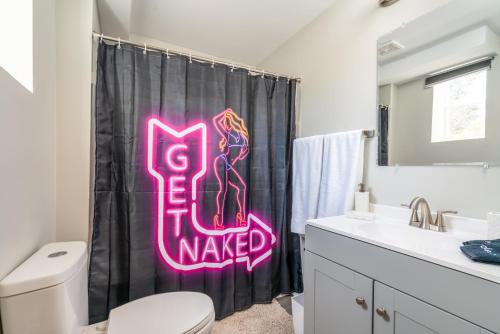 a bathroom with a neon sign on the shower curtain at Cozy 1 bed APT near Five Points! Bring your pets! in Columbia