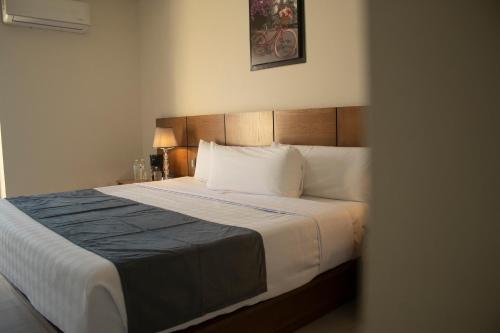 a bedroom with a large bed with white sheets and pillows at hotel vista valle in Tepic