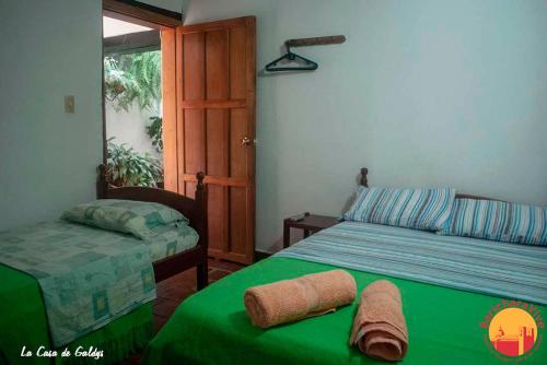 a bedroom with a green bed and a window at La Casa De Gladys in Barichara