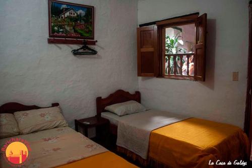 a room with two beds and a window at La Casa De Gladys in Barichara
