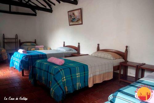 a bedroom with three beds in a room at La Casa De Gladys in Barichara