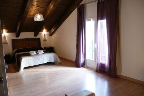 1 dormitorio con cama y ventana grande en Puerta de Ordesa Garden, en Laspuña