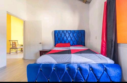 a bed in a room with a blue head board at Sunflower village villa girasoles in Jarabacoa