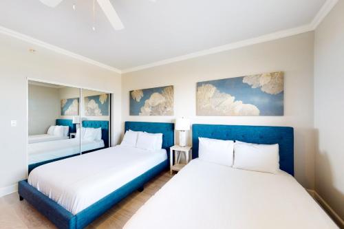 two beds in a room with blue and white at Navarre Beach Regency 805 in Navarre