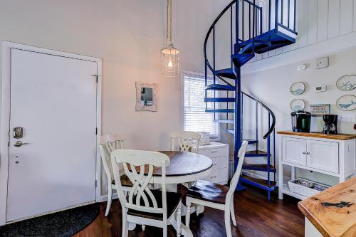 a dining room with a table and a blue spiral staircase at Driftwood Villa - 269 in Edisto Island
