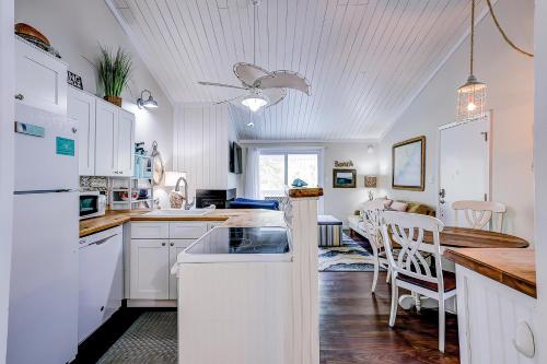 a kitchen with white cabinets and a dining room at Driftwood Villa - 269 in Edisto Island