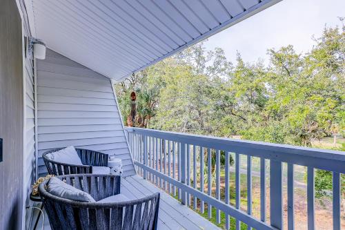 a porch with two chairs and a view of trees at Driftwood Villa - 269 in Edisto Island