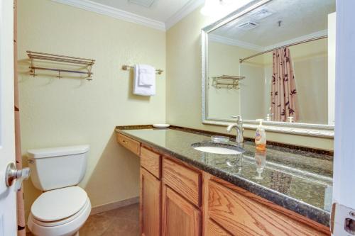 a bathroom with a toilet and a sink and a mirror at Pirates Bay A410 in Fort Walton Beach