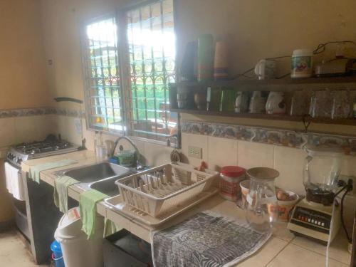 a kitchen with a sink and a dish drying rack at PaCasa Hostel in David
