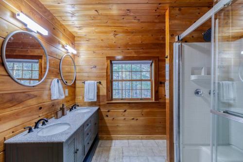 a bathroom with wooden walls and a glass shower at Gorgeous 6BR Cabin w/Spa, Firepit, Arcade& Mountain View in Mineral Bluff