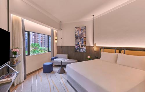 a hotel room with a large bed and a window at Pullman Singapore Orchard in Singapore