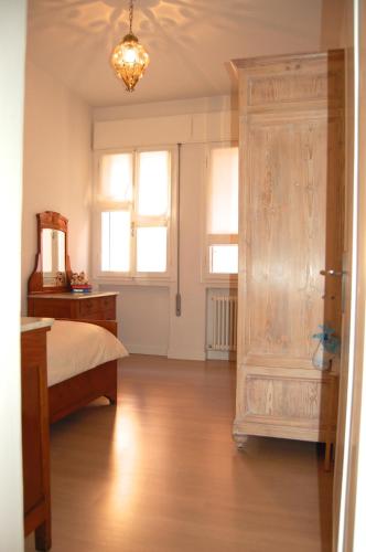 a bedroom with a bed and a dresser and windows at Casa Roberto in Treviso