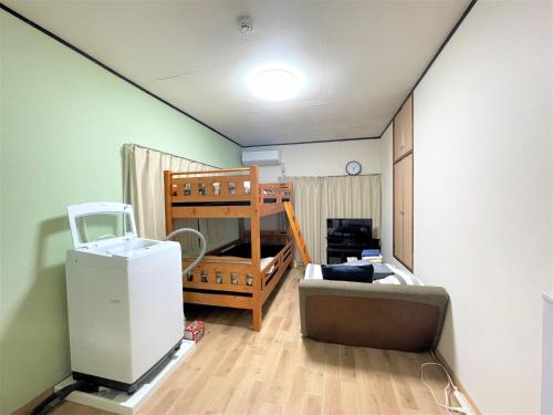 a room with a bunk bed and a couch at House Kadoi202 in Tokyo