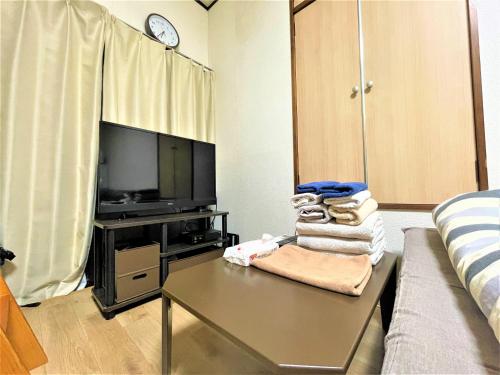 a living room with a couch and a table and a tv at House Kadoi202 in Tokyo