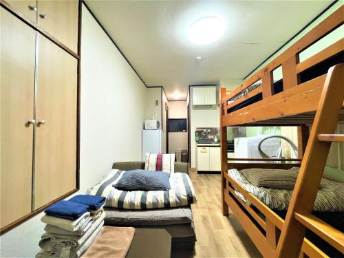 a small room with bunk beds and a kitchen at House Kadoi202 in Tokyo