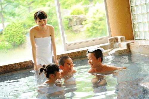 a woman and children in a swimming pool at Onogawa Onsen Kajikaso in Yonezawa