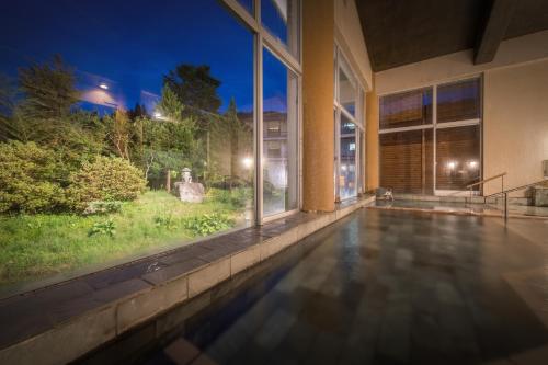 an indoor swimming pool in a building at night at Onogawa Onsen Kajikaso in Yonezawa