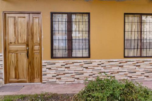 a building with two doors and three windows at Apartamento Daly 3 in Guápiles
