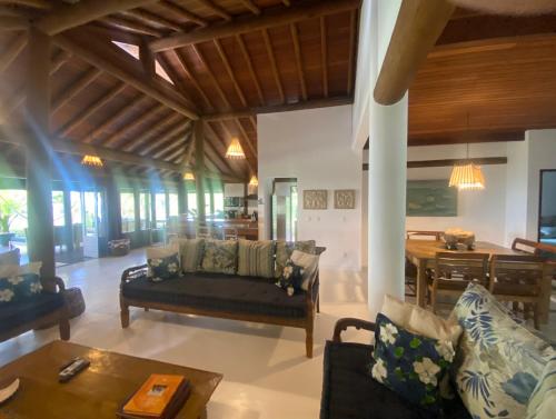 uma sala de estar com um sofá e uma mesa em Villa Oberoi pé na areia alto luxo em Santo André