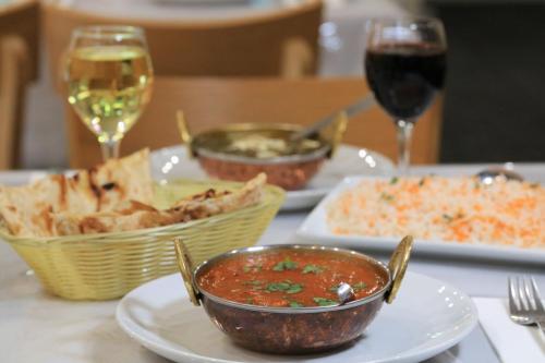 a table with plates of food and glasses of wine at Cootamundra Gardens Motel in Cootamundra