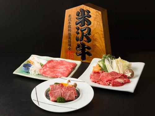 two plates of food with meat and vegetables on a table at Onogawa Onsen Kajikaso in Yonezawa