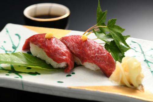 two slices of grapefruit on a plate with greens at Onogawa Onsen Kajikaso in Yonezawa