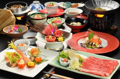 a table with plates of food and bowls of food at Onogawa Onsen Kajikaso in Yonezawa