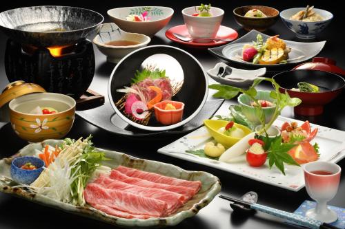 a table with plates of food and bowls of food at Onogawa Onsen Kajikaso in Yonezawa