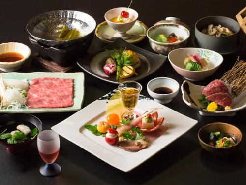 a table with plates of food and bowls of food at Onogawa Onsen Kajikaso in Yonezawa