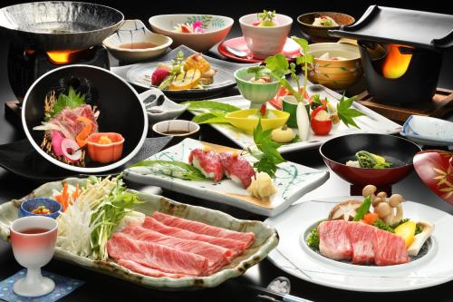 a table with many plates of food on it at Onogawa Onsen Kajikaso in Yonezawa