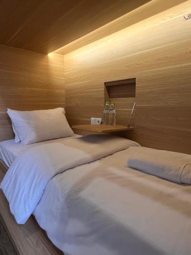 two beds sitting next to each other in a room at Sleep Studio Hotel City Center Surabaya in Tembok