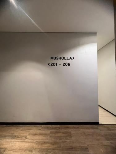 a white wall with the name of a museum at Sleep Studio Hotel City Center Surabaya in Tembok