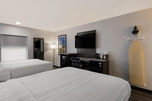a hotel room with two beds and a flat screen tv at Quality Inn South Bend near Notre Dame in South Bend