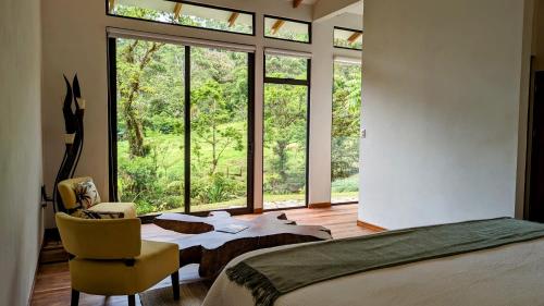 1 dormitorio con cama y ventana grande en UNFORGETTABLE PLACE,Monteverde Casa Mia near main attractions and town, en Monteverde