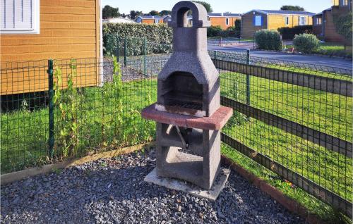 un four en pierre assis à côté d'une clôture dans l'établissement Pet Friendly StaCaravan, à Grandcamp-Maisy