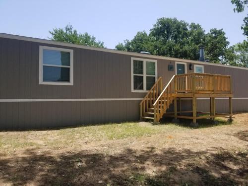 a modular home with a porch and a deck at Lakefront Wakezone - 37 in Mead