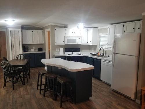 a kitchen with white cabinets and a white refrigerator at Lakefront Wakezone - 37 in Mead
